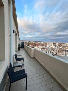 een balkon met 2 stoelen en uitzicht op de stad bij Ermes Apartment - Historic Centre Catania in Catania