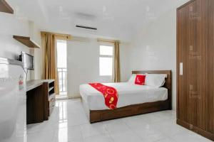 1 dormitorio con cama y ventana grande en RedLiving Apartemen Margonda Residence 2 - Tower 2 en Pondokcina