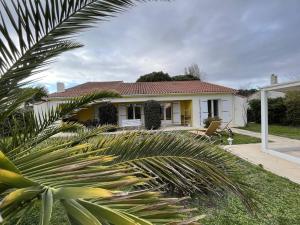 a yellow house with a palm tree in front of it at Grande Maison Familiale avec SPA, Plage à Proximité, Jardin et Parking - 10 Couchages - FR-1-246A-153 in Grand-Village-Plage