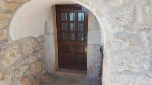 a wooden door in a stone building with an archway at CAPITANO di CHERSO VIP holidays, gourmet & sail experience in Dragozetići
