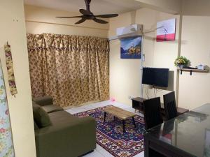 een woonkamer met een bank en een plafondventilator bij JoeRos Homestay in Shah Alam