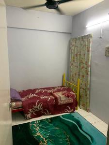 een kleine kamer met een bed met een gordijn en een tapijt bij JoeRos Homestay in Shah Alam