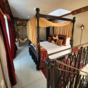 a bedroom with a canopy bed in a room at Excalibur Boutique Hotel in Rustenburg