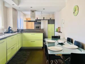 a kitchen with green cabinets and a table with chairs at Housingleon Ordoño II in León