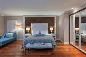 a bedroom with a bed and a blue couch at Elite World Istanbul Florya in Istanbul