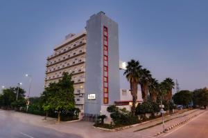 un grande edificio bianco con una striscia rossa sopra di Red Fox Hotel, East Delhi a Nuova Delhi