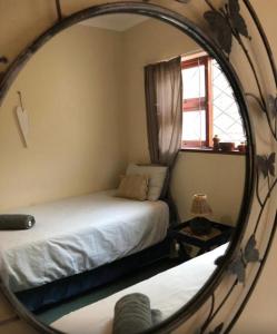 a mirror in a room with a bed and a window at Grand Yellow Apartment in Port Alfred