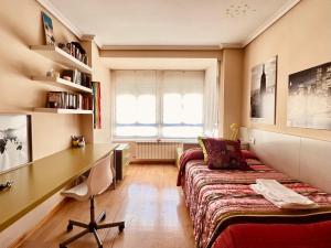 een slaapkamer met een bed en een bureau bij Housingleon Ordoño II in León