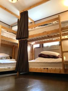 two bunk beds are in a room withthritisthritisthritisthritisthritisthritisthritisthritis at IZA Kamakura Guest House and Bar in Kamakura