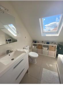 uma casa de banho com um lavatório, um WC e um espelho. em Maison au calme avec piscine près de Truchtersheim, à 15 minutes de Strasbourg em Durningen