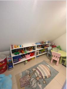 uma sala de jogos para crianças com uma prateleira com brinquedos em Maison au calme avec piscine près de Truchtersheim, à 15 minutes de Strasbourg em Durningen