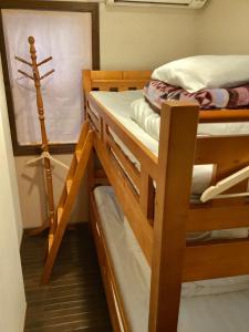 2 Etagenbetten in einem kleinen Zimmer mit Fenster in der Unterkunft IZA Kamakura Guest House and Bar in Kamakura