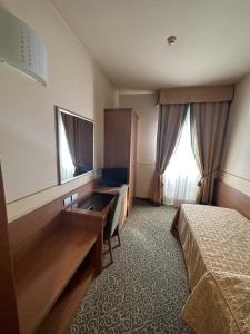 una camera d'albergo con due letti e uno specchio di Hotel Kristall a Corsico