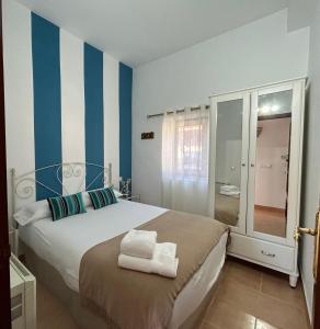 een slaapkamer met een bed met blauwe en witte strepen bij El valle de Lis in Praves