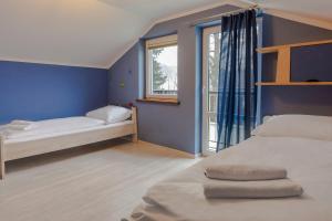 um quarto azul com duas camas e uma janela em VacationClub – 300 Mill Pokój 5 em Szklarska Poręba