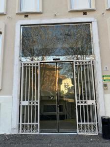 un accès à un bâtiment avec une porte en verre dans l'établissement Hotel Kristall, à Corsico