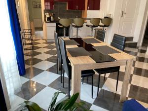 a dining room with a table and chairs and a kitchen at Calme et spacieux près du Loing et du centre in Moret-sur-Loing