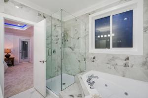 a bathroom with a tub and a glass shower at Sun suite in Surrey