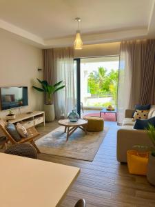 een woonkamer met een bank en een tafel bij Tropical beachfront apartment in Belle Mare