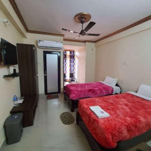 Habitación de hotel con 2 camas y espejo en Wildlife Guest House, en Hatikhuli