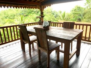 a wooden table and two chairs on a deck at Villa Kepuh in Kubutambahan