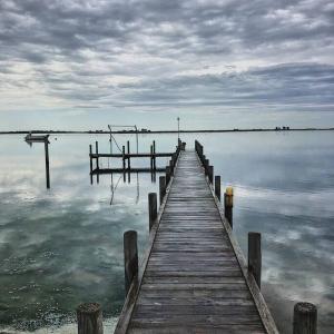 un muelle de madera en medio de una masa de agua en Hideaway Tom’s on Mundoo Channel - Waterfront, en Hindmarsh Island