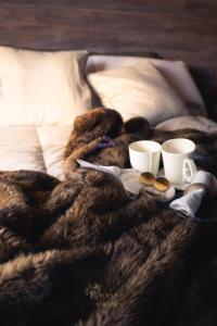 Una cama con dos tazas de café y una bandeja de comida. en Dormire in una Botte, en Angri