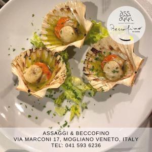 Een bord met oesters en groenten erop. bij Relais Totì BeB bed e breakfast in Mogliano Veneto