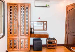 a room with a desk and a wooden cabinet at Sbay Hotel Đà Nẵng in Da Nang