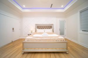 a white bedroom with a bed in a room at Sun suite in Surrey
