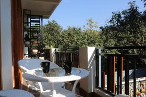 a white table and chairs on a balcony with a view at Barefoot Homestays in Rāmnagar