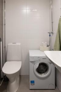 a white bathroom with a toilet and a washing machine at Studio apartment in central Turku in Turku