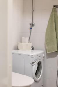 a bathroom with a washing machine and a toilet at Studio apartment in central Turku in Turku