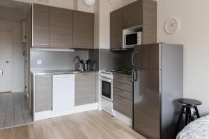 a kitchen with a stainless steel refrigerator and cabinets at Studio apartment in central Turku in Turku