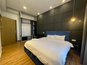 um quarto com uma grande cama branca e uma cabeceira azul em SRT Suites - The Skyline em Phnom Penh