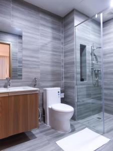 a bathroom with a toilet and a shower and a sink at SRT Suites - The Skyline in Phnom Penh