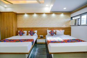 Postel nebo postele na pokoji v ubytování FabHotel Galaxy Stay - Nr Morya Hospital