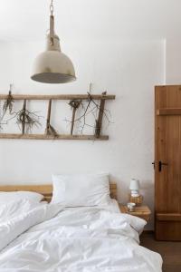 ein Schlafzimmer mit einem Bett mit weißer Bettwäsche und einer Lampe in der Unterkunft Sloho Bergurlaub in Hohentauern