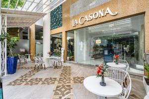 La Casona Hotel في مدينة هوشي منه: متجر أمام متجر مع طاولات وكراسي