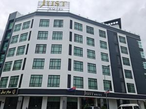 um edifício branco com uma placa em cima em Just Hotel BP em Batu Pahat