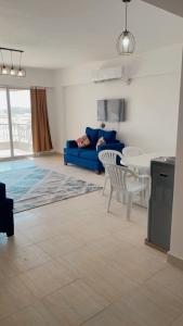uma sala de estar com um sofá azul e uma mesa em شاليه فندقى سياحى em Ain Sokhna