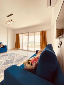شاليه فندقى سياحى في العين السخنة: غرفة معيشة مع أريكة زرقاء ونافذة كبيرة