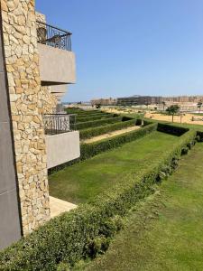 a row of hedges next to a stone building at شاليه فندقى سياحى in Ain Sokhna