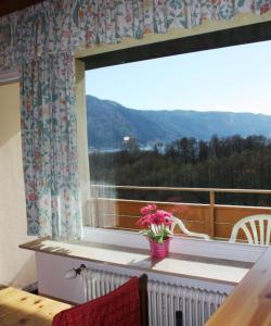 una ventana con un jarrón de flores en el balcón en ROBERTO Haus KMB Seeappartement direkt am Ossiacher See mit Hallenbad en Tschöran