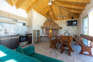 een keuken en een woonkamer met een tafel en een open haard bij Villa Relax with sauna & jacuzzi &gym in Gornji Zemunik