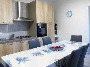 una cocina con una mesa con un bol de fruta. en Casa Maia, en Casalabate