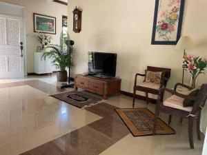 sala de estar con TV sobre una mesa de madera en Lui Farm Villa - Private Villa for Staycation & Retreat, en Hulu Langat