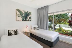 two beds in a room with a window at Element on Coolum Beachfront Sunshine Coast in Coolum Beach +231 photos