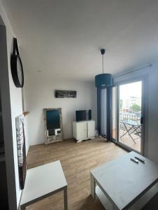 een woonkamer met een tafel en een spiegel bij Superbe studio à Canet en Roussillon proche de la plage in Canet-en-Roussillon