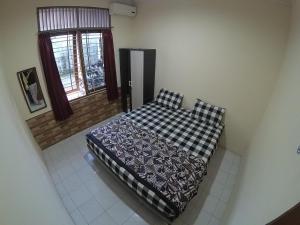 Schlafzimmer mit einem Bett und einem Fenster in der Unterkunft Omah Nandan Homestay Jogja in Kejayan